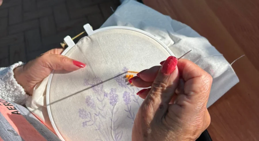 Las manos de una mujer de la tercera edad tejiendo.