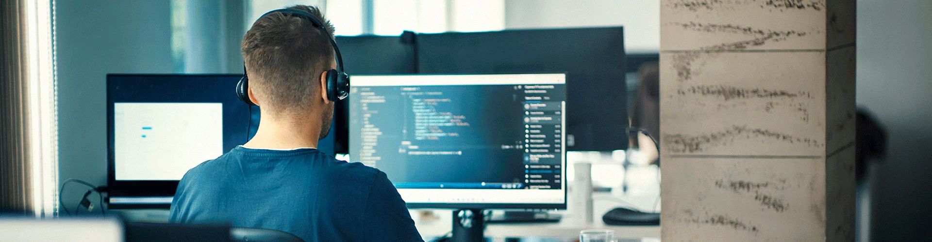 Ingeniero de sistemas programando en una pantalla grande - Utadeo