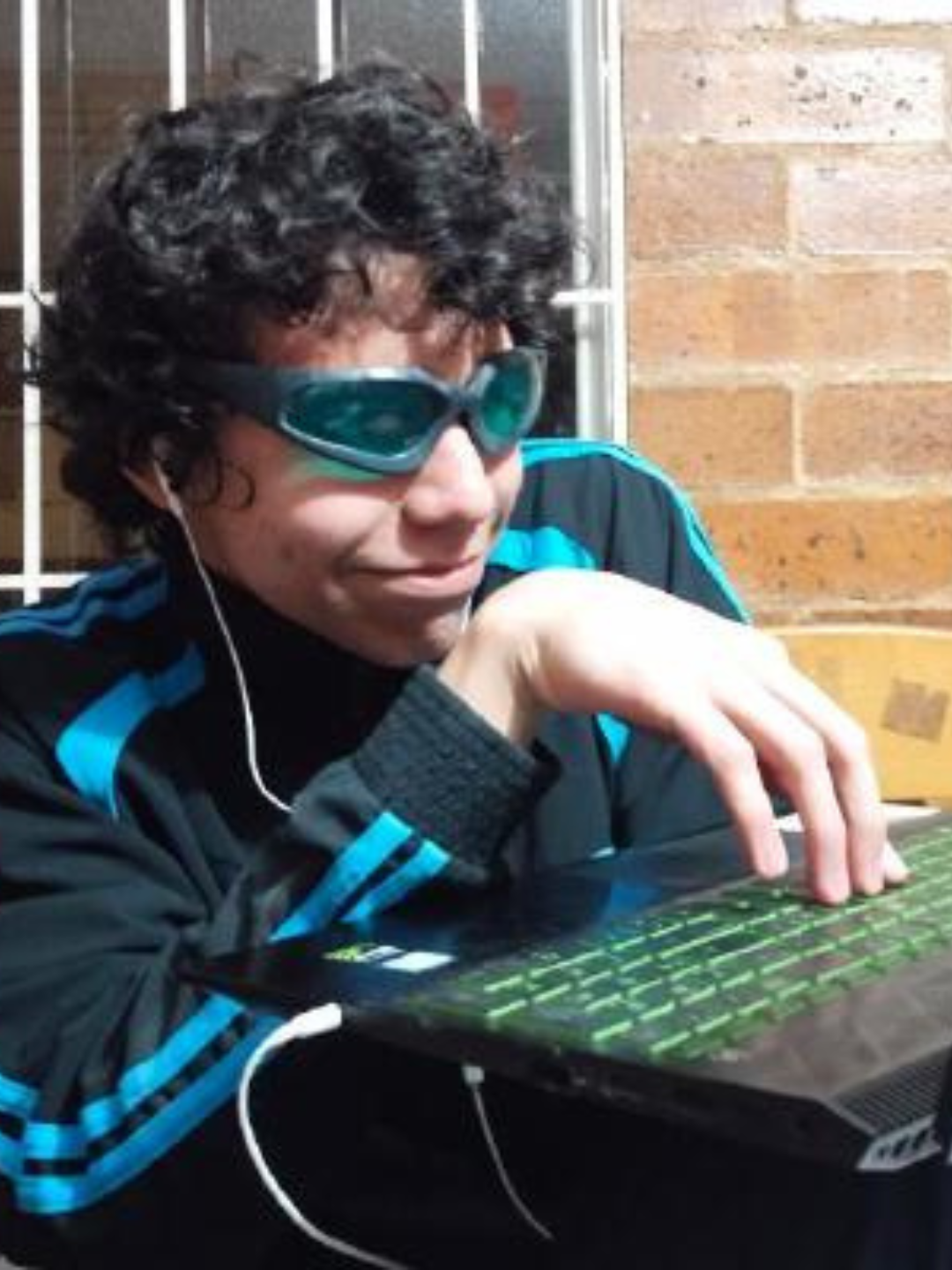 FOTO DE LUDWIG MAURICIO ALVARADO BECERRA USANDO GAFAS Y CON UNA MANO SOBRE UNA LAPTOP