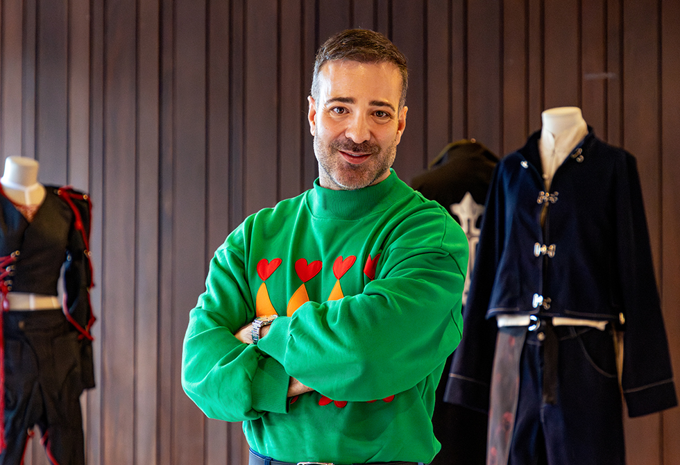 Francisco López posando frente a diseños de estudiantes de Utadeo