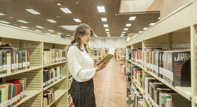 Estudiante leyendo un libro colombiano en la biblioteca de Utadeo
