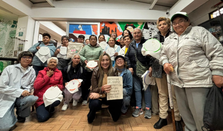 Estudiantes de Utadeo posan junto a un grupo de adultas mayores con quienes comparten en un taller de tejido