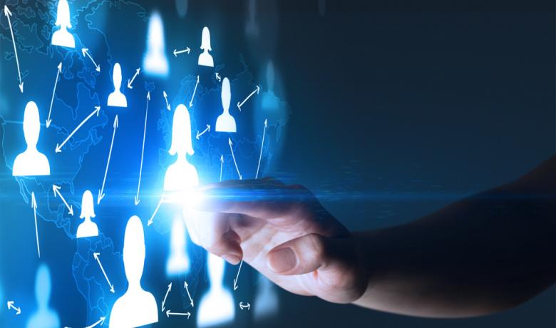 Una mano tocando una pantalla azul con íconos de hombres y mujeres interconectados.
