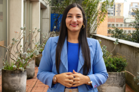 Diana Laverde, jefe de comunicaciones de Utadeo, posando frente a la cámara con sus manos entrelazadas