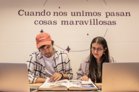Dos estudiantes jóvenes de periodismo analizando un libro