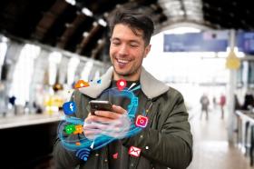 Hombre sostiene celular e interactúa en redes sociales 