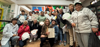 Estudiantes de Utadeo posan junto a un grupo de adultas mayores con quienes comparten en un taller de tejido