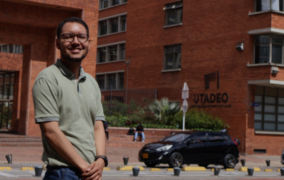 Foto de Santiago Abel Cabarcas Julio junto al logo de Utadeo en la entrada principal