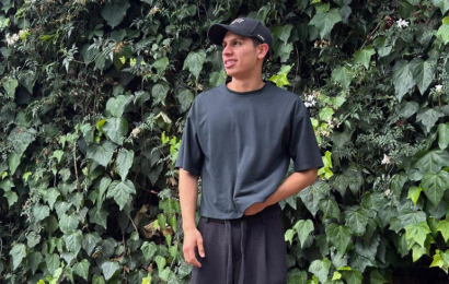 Santiago Aldana Isaza posando frente a un muro de plantas