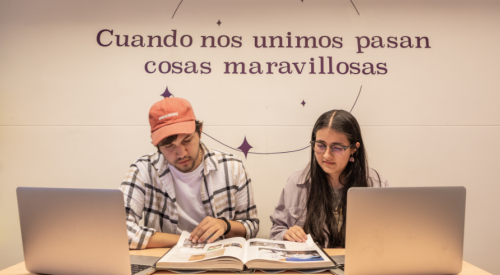 Dos estudiantes jóvenes de periodismo analizando un libro